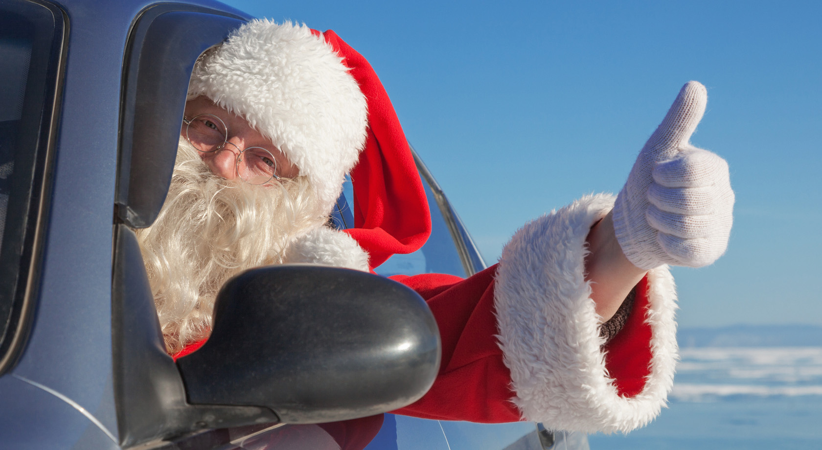 Santa in a car with a thumbs up